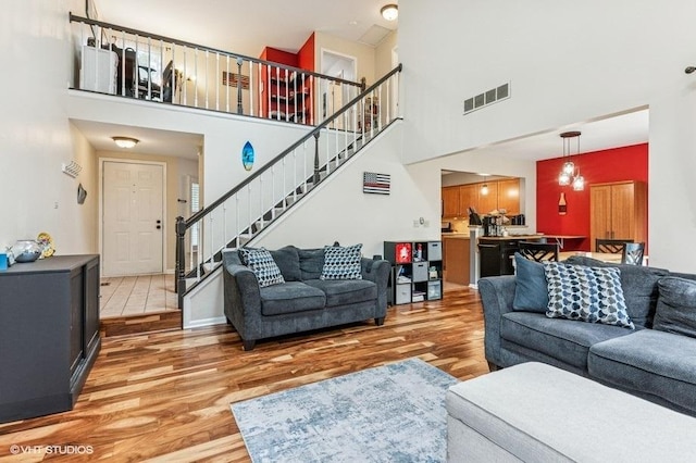 1063 Ridgefield Cir, Carol Stream, IL 60188 - living area featuring light wood-style floors, a towering ceiling, and stairs