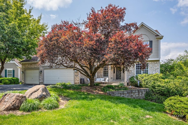 605 Birch Ln, Fox River Grove, IL 60021 - obstructed view of property with stone siding, asphalt driveway, an attached garage, and a front lawn