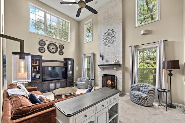 605 Birch Ln, Fox River Grove, IL 60021 - living room featuring a high ceiling, a ceiling fan, a stone fireplace, carpet floors, and healthy amount of natural light
