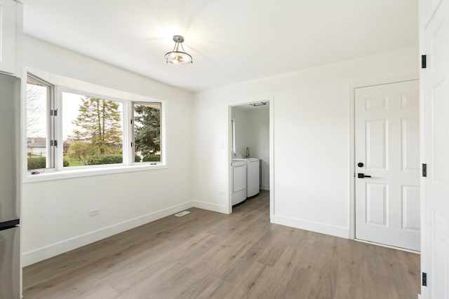 7723 W 157th St, Orland Park, IL 60462 - unfurnished bedroom featuring separate washer and dryer, light wood-type flooring, baseboards, and freestanding refrigerator