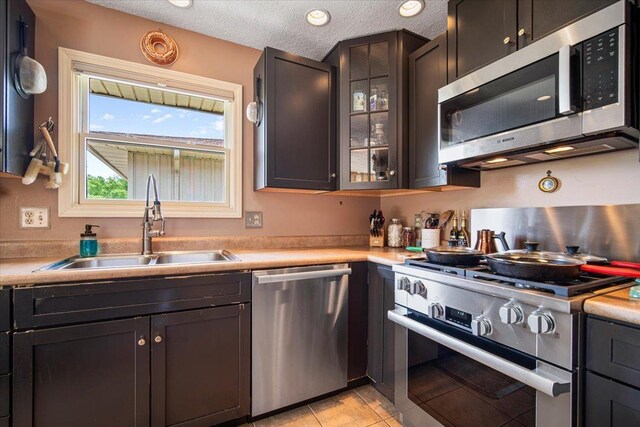 315 S Bone Dr, Normal, IL 61761 - kitchen featuring stainless steel appliances, light countertops, light tile patterned floors, and glass insert cabinets