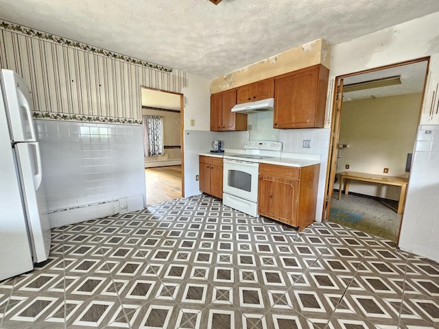1212 N Mill St, Pontiac, IL 61764 - kitchen with white appliances, under cabinet range hood, light countertops, a baseboard heating unit, and tile patterned floors