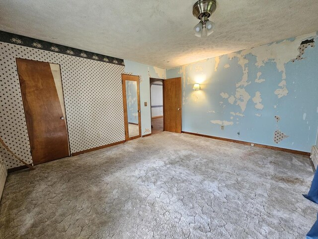 1212 N Mill St, Pontiac, IL 61764 - carpeted empty room with a textured ceiling, a baseboard radiator, and wallpapered walls