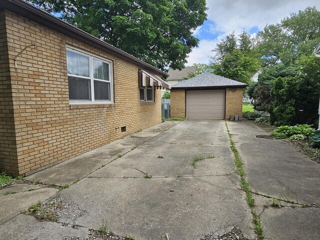 1212 N Mill St, Pontiac, IL 61764 - view of side of home featuring an outbuilding, concrete driveway, brick siding, and a garage