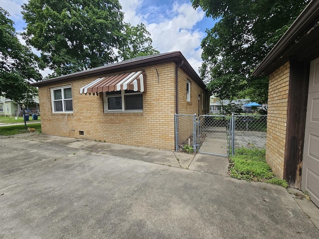 1212 N Mill St, Pontiac, IL 61764 - view of property exterior with brick siding, a gate, and crawl space