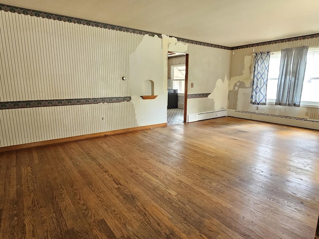 1212 N Mill St, Pontiac, IL 61764 - spare room with wood finished floors, wallpapered walls, and baseboard heating