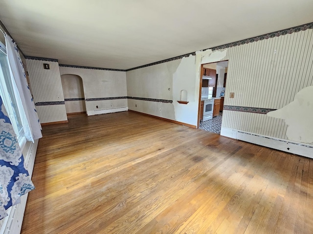 1212 N Mill St, Pontiac, IL 61764 - unfurnished room with wood-type flooring, arched walkways, and wallpapered walls