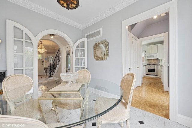 1025 Sheridan Rd, Wilmette, IL 60091 - dining room with stairs, arched walkways, crown molding, a chandelier, and baseboards