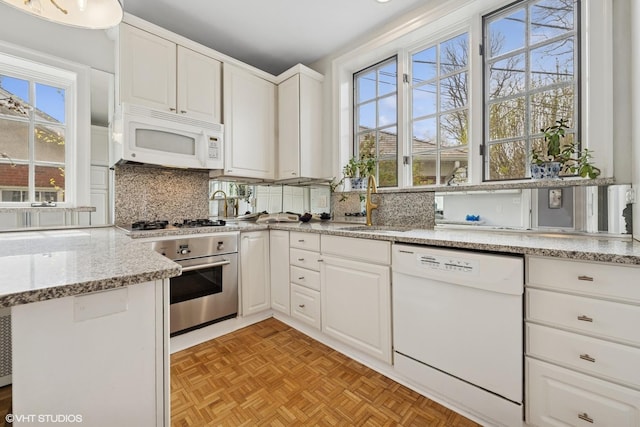 1025 Sheridan Rd, Wilmette, IL 60091 - kitchen with appliances with stainless steel finishes, a sink, white cabinetry, tasteful backsplash, and plenty of natural light