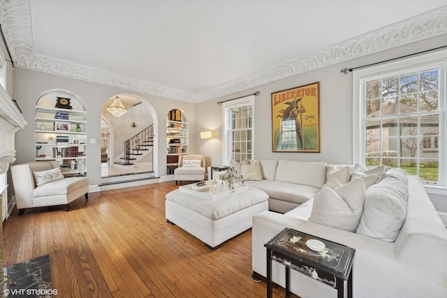 1025 Sheridan Rd, Wilmette, IL 60091 - living area featuring built in shelves, wood-type flooring, arched walkways, and crown molding