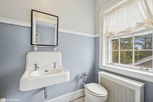 1025 Sheridan Rd, Wilmette, IL 60091 - half bathroom featuring radiator heating unit, toilet, baseboards, and a sink