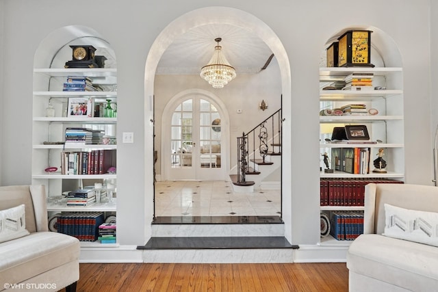 1025 Sheridan Rd, Wilmette, IL 60091 - entryway featuring arched walkways, stairs, a chandelier, wood finished floors, and french doors