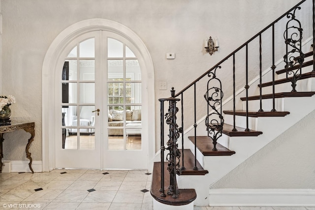 1025 Sheridan Rd, Wilmette, IL 60091 - stairs with french doors, arched walkways, and a textured wall