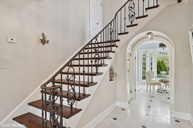 1025 Sheridan Rd, Wilmette, IL 60091 - staircase featuring arched walkways, baseboards, a high ceiling, and tile patterned floors