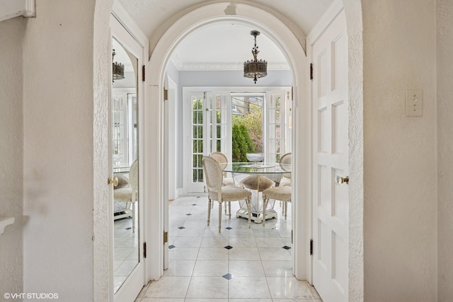 1025 Sheridan Rd, Wilmette, IL 60091 - interior space featuring arched walkways, a textured wall, light tile patterned floors, baseboards, and a chandelier