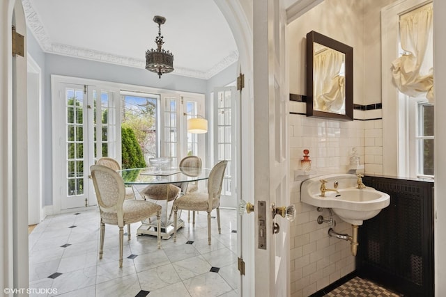 1025 Sheridan Rd, Wilmette, IL 60091 - dining space with ornamental molding, tile walls, arched walkways, light tile patterned floors, and radiator heating unit