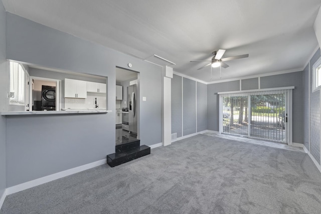 15603 Park Ln, South Holland, IL 60473 - unfurnished living room featuring ceiling fan, stacked washing machine and dryer, carpet, baseboards, and crown molding