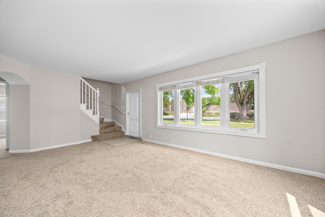 4117 W 99th St, Oak Lawn, IL 60453 - unfurnished living room with carpet flooring, arched walkways, baseboards, and stairway