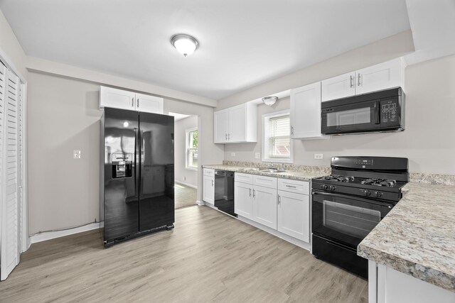 4117 W 99th St, Oak Lawn, IL 60453 - kitchen with black appliances, white cabinets, light wood-type flooring, and light countertops