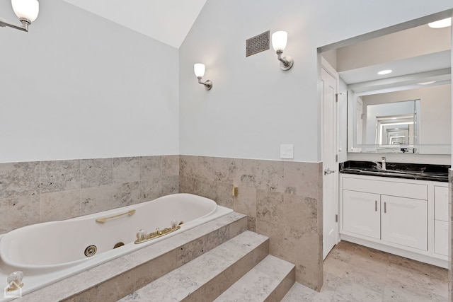 9317 Firth Ct, Lakewood, IL 60014 - full bath featuring vanity, lofted ceiling, a tub with jets, a wainscoted wall, and tile walls