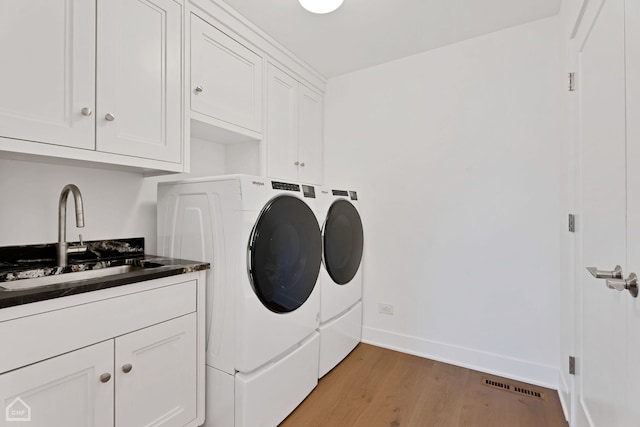 9317 Firth Ct, Lakewood, IL 60014 - laundry room with washer and dryer, cabinet space, light wood-type flooring, and baseboards