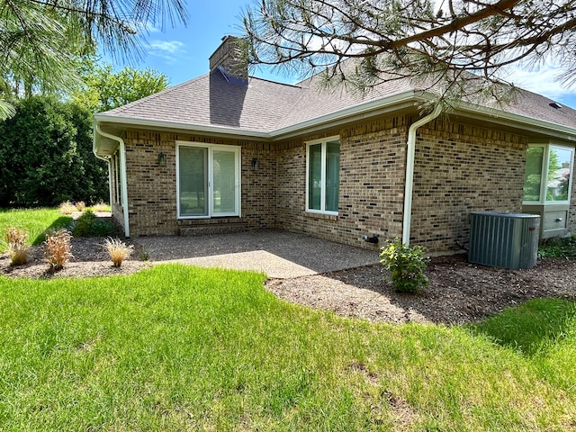 9317 Firth Ct, Lakewood, IL 60014 - rear view of property with central AC, a chimney, a yard, a patio, and brick siding