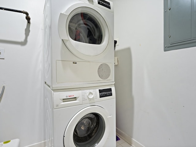 4537 S Drexel Blvd Unit 303, Chicago, IL 60653 - washroom featuring stacked washer and clothes dryer, electric panel, baseboards, and light tile patterned floors
