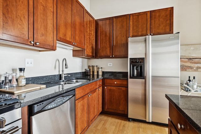 1503 S State St Unit 606, Chicago, IL 60605 - kitchen featuring appliances with stainless steel finishes, dark stone countertops, light wood-style floors, and brown cabinets