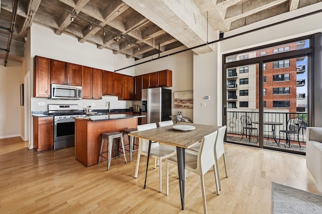 1503 S State St Unit 606, Chicago, IL 60605 - kitchen with appliances with stainless steel finishes, a towering ceiling, light wood-type flooring, a breakfast bar area, and a center island