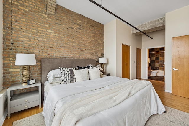 1503 S State St Unit 606, Chicago, IL 60605 - bedroom with a high ceiling, wood finished floors, brick wall, and ensuite bathroom