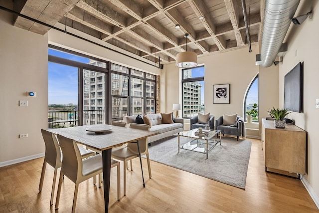 1503 S State St Unit 606, Chicago, IL 60605 - dining space featuring plenty of natural light, light wood-style flooring, a wooden ceiling with exposed beams, and a towering ceiling