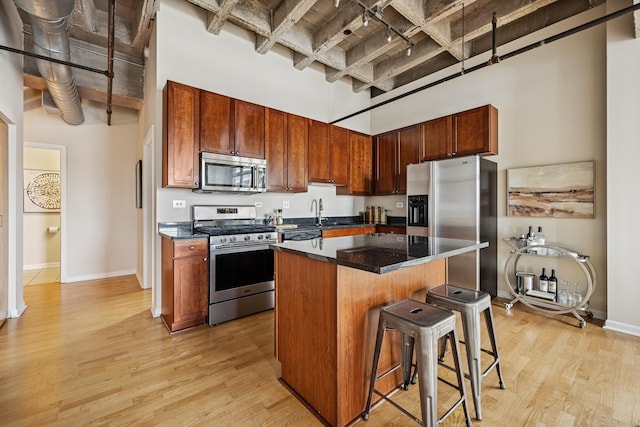 1503 S State St Unit 606, Chicago, IL 60605 - kitchen with stainless steel appliances, a kitchen bar, a center island, light wood-style flooring, and beam ceiling