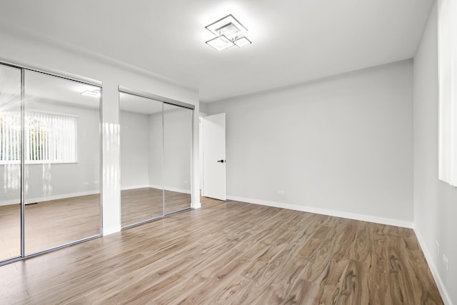 4574 Whitney Dr, Hanover Park, IL 60133 - unfurnished bedroom with multiple closets, wood finished floors, and baseboards