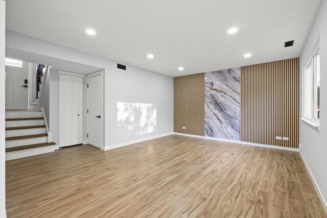 4574 Whitney Dr, Hanover Park, IL 60133 - unfurnished living room with an accent wall, stairway, light wood-style floors, recessed lighting, and baseboards