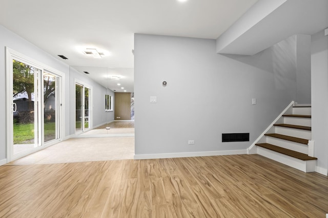 4574 Whitney Dr, Hanover Park, IL 60133 - unfurnished living room with light wood-style flooring, stairs, and baseboards