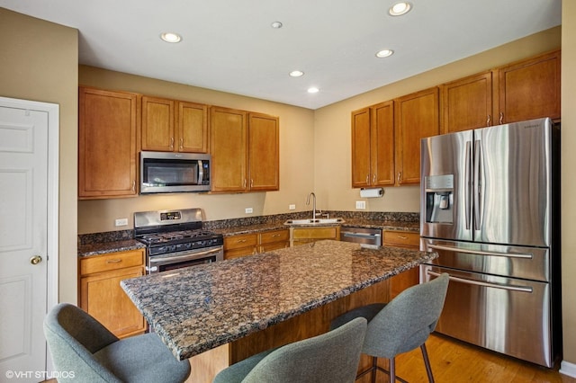 6068 Halloran Ln, Hoffman Estates, IL 60192 - kitchen featuring appliances with stainless steel finishes, a sink, a breakfast bar, recessed lighting, and light wood-type flooring