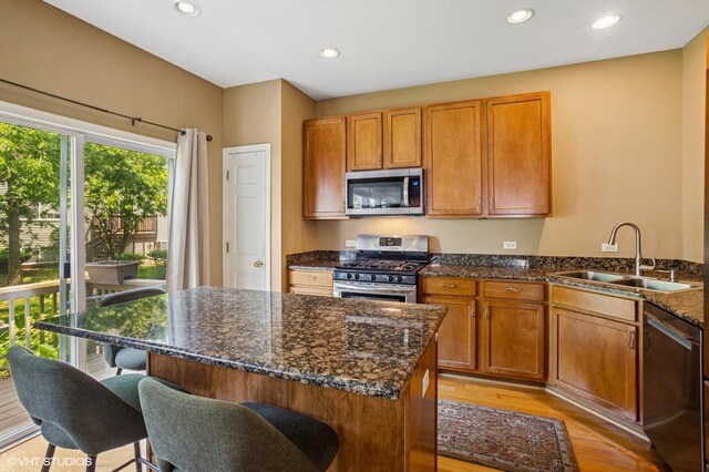 6068 Halloran Ln, Hoffman Estates, IL 60192 - kitchen featuring appliances with stainless steel finishes, a sink, a breakfast bar area, light wood-style floors, and recessed lighting
