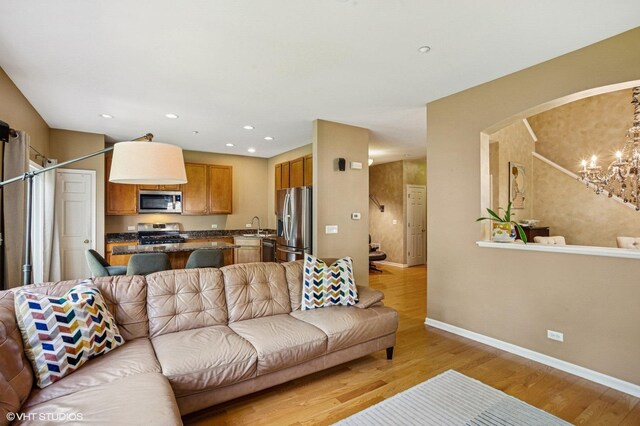 6068 Halloran Ln, Hoffman Estates, IL 60192 - living room with arched walkways, light wood-style flooring, a chandelier, baseboards, and recessed lighting