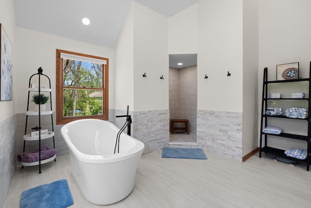 2905 Rose Ave, Mchenry, IL 60050 - bathroom featuring tile walls, a wainscoted wall, a soaking tub, and high vaulted ceiling