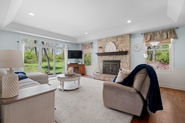 2905 Rose Ave, Mchenry, IL 60050 - living room featuring wood-type flooring, healthy amount of natural light, wainscoting, a stone fireplace, and recessed lighting