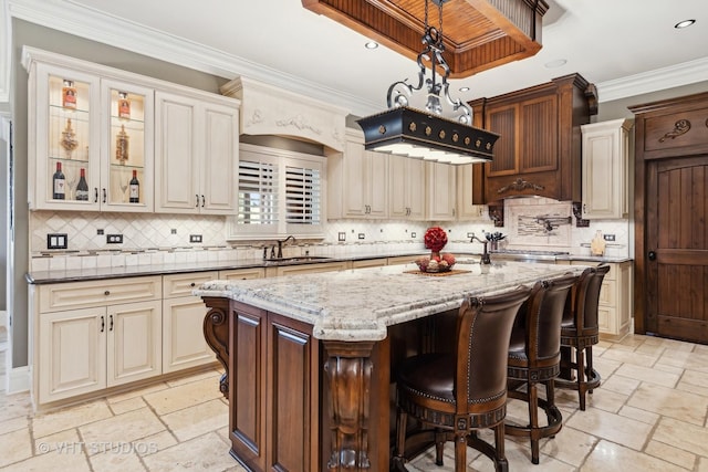 22957 Devonshire Ln, Frankfort, IL 60423 - kitchen featuring stone tile flooring, a center island, light stone countertops, decorative backsplash, and crown molding