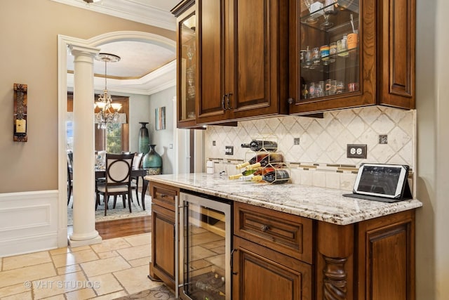 22957 Devonshire Ln, Frankfort, IL 60423 - bar area featuring beverage cooler, ornate columns, a chandelier, stone tile flooring, and decorative backsplash