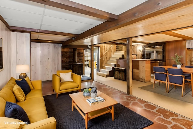 427 Lawrence Ave, Grayslake, IL 60030 - living area featuring wooden walls, a wood stove, stairway, beamed ceiling, and concrete floors