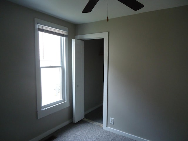 12438 Maple Ave, Blue Island, IL 60406 - unfurnished bedroom with multiple windows, carpet flooring, baseboards, and a ceiling fan