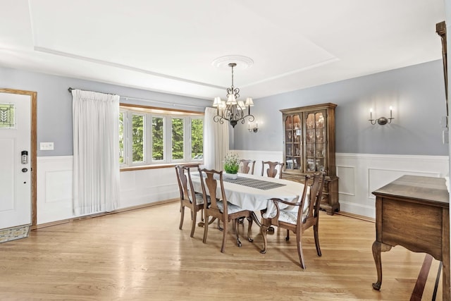13843 W Stoneoak Way, Homer Glen, IL 60491 - dining room with a tray ceiling, light wood-style flooring, a chandelier, wainscoting, and a decorative wall