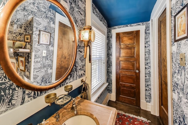 1701 W Chase Ave, Chicago, IL 60626 - bathroom featuring wallpapered walls, a sink, wood finished floors, and baseboards