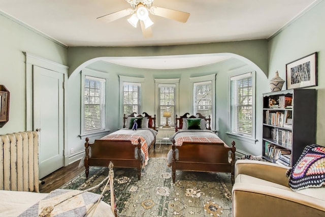 1701 W Chase Ave, Chicago, IL 60626 - bedroom featuring arched walkways, radiator heating unit, wood finished floors, and a ceiling fan