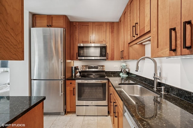 450 W Briar Pl Unit 12G, Chicago, IL 60657 - kitchen with appliances with stainless steel finishes, brown cabinets, a sink, and dark stone countertops