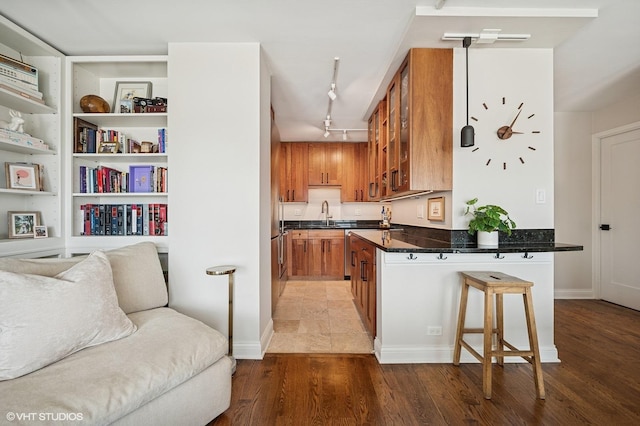 450 W Briar Pl Unit 12G, Chicago, IL 60657 - kitchen featuring brown cabinets, open floor plan, a kitchen bar, glass insert cabinets, and a peninsula