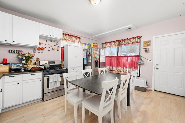 3034 S Komensky Ave, Chicago, IL 60623 - kitchen with stainless steel appliances, light wood-type flooring, white cabinetry, and dark countertops